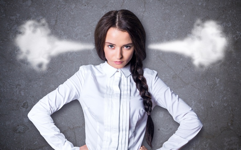 An angry woman with steam appearing to come out of her ears